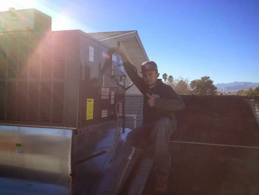 HVAC technician performing HVAC Inspection on a rooftop unit in Fitzgerald